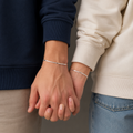 Two people holding hands with a neutral background